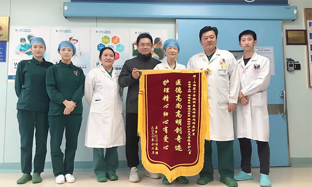 患者家屬贈送錦旗并與李主任團隊合影